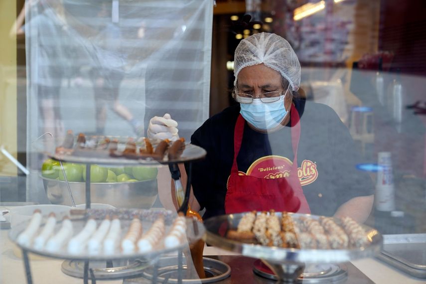 Una trabajadora usa una mascarilla mientras prepara postres en el Universal City Walk, el viernes 14 de mayo de 2021 en Universal City, California