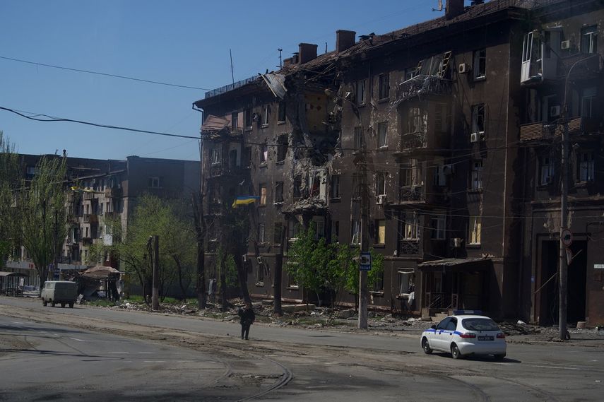 Una persona camina por una calle frente a un edificio residencial carbonizado en la ciudad de Mariupol el 29 de abril de 2022, en medio de la acción militar rusa en curso en Ucrania. &nbsp;