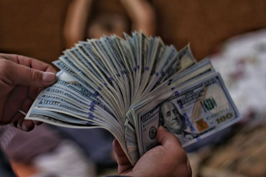 Hombre con un conjunto de billetes de 100 dólares