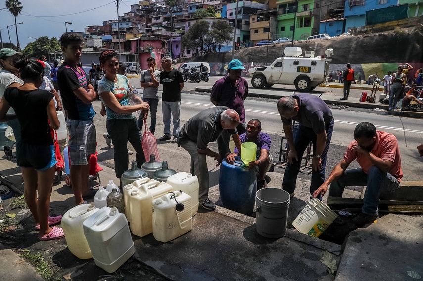 Varias personas buscan agua en el sector El Cementerio, en Caracas, en medio del racionamiento eléctrico dispuesto por el régimen de Nicolás Maduro y de la crisis que mantiene sin luz a buena parte de la capital y del país.