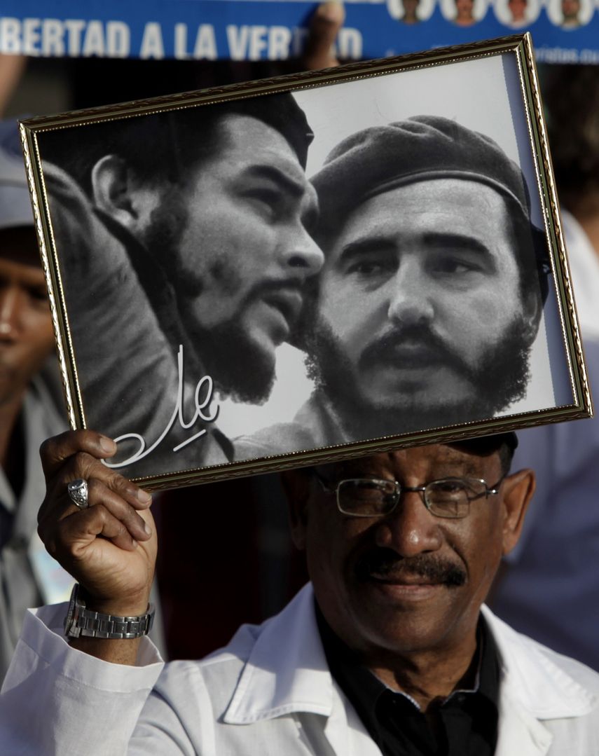 Fotograf&iacute;a del 1ro de mayo de 2009 de un hombre que sostiene una foto del Che Guevara y Fidel Castro en La Habana, Cuba.