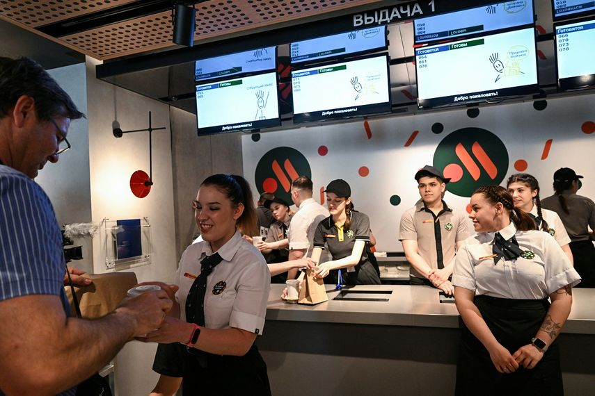 Un empleado le da a un cliente su pedido de comida en la versión rusa de un antiguo restaurante McDonalds después de la ceremonia de apertura en Moscú el 12 de junio de 2022.&nbsp;&nbsp;