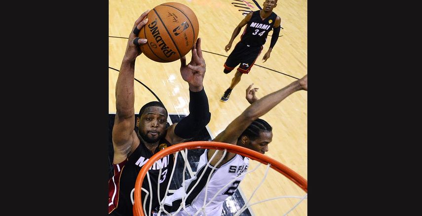 Dwyane Wade, del Heat de Miami, intenta clavar el balón ante la presión defensiva de Kawhi Leonard, de los Spurs de San Antonio, en la primera mitad del segundo juego de la serie final de la NBA. (AP)