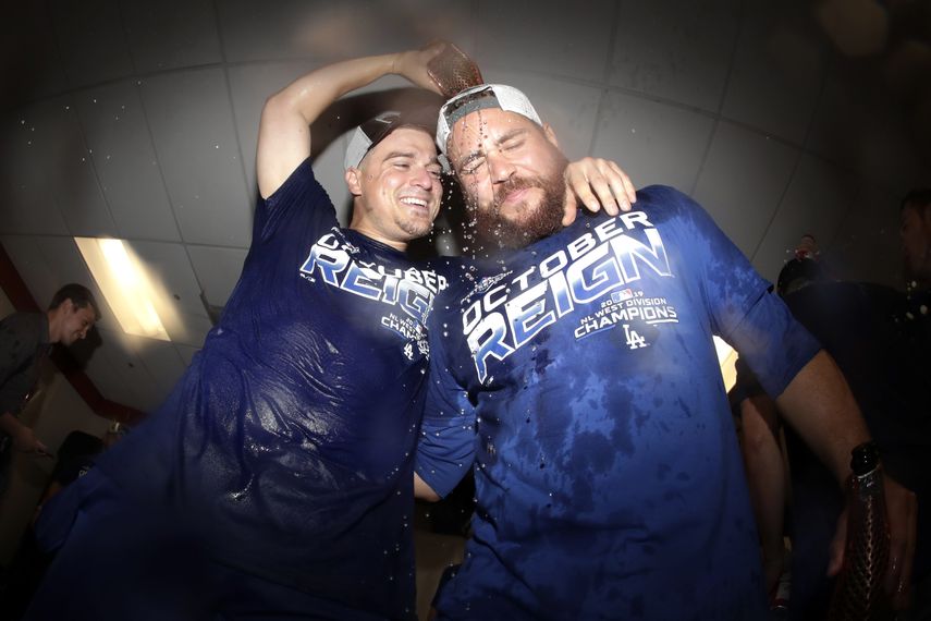 El puertorrique&ntilde;o Kik&eacute; Hern&aacute;ndez (izquierda), de los Dodgers de Los &Aacute;ngeles, arroja cerveza sobre Russell Martin, tras la conquista del gallardete de la Divisi&oacute;n Oeste de la Liga Nacional, el martes 10 de septiembre de 2019, en Baltimore&nbsp;