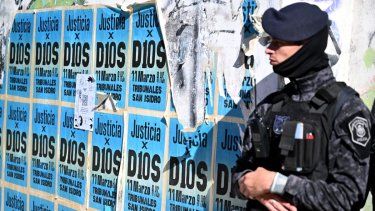 Un miembro de las Fuerzas Especiales de Argentina hace guardia junto a una pared llena de letreros en apoyo al fallecido astro del fútbol, Diego Maradona, el 3 de abril de 2025.