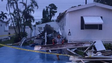 Una mujer mueve los escombros que dejó un tornado asociado al paso de la tormenta tropical Philippe en Boyton Beach, Florida.