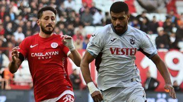 El jugador del Antalyaspor, Sagiv Jehezkel, a la izquierda, lucha por el balón con el jugador del Trabzonspor, Rayyan Baniya, durante un partido de la Superliga turca en Anta Antalyaspor and Trabzonspor en Antalya, en el sur de Turquía, el domingo 14 de enero de 2024.