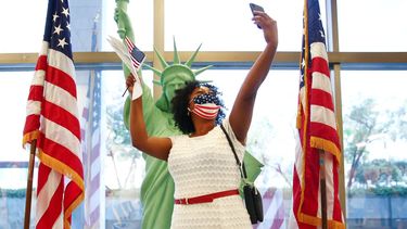 Una mujer posa dentro de unos de los centros de atención de USCIS, luego de obtener su estatus de ciudadanía estadounidense.&nbsp;