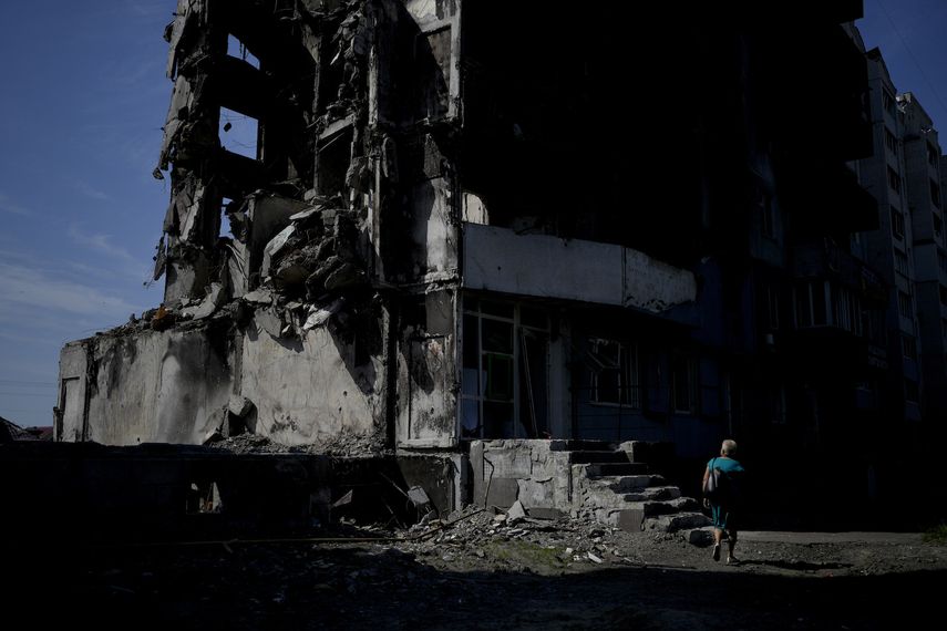 Una mujer camina junto a un edificio destruido por los bombardeos rusos en Borodyanka, en las afueras de Kiev, Ucrania, el martes 21 de junio de 2022.&nbsp;