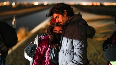 Dos cubanos aguardan a ser procesados después de cruzar la frontera con México y entregarse a las autoridades estadounidenses para solicitar asilo, el 6 de enero de 2023, cerca de Yuma, Arizona.&nbsp;