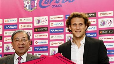 Uruguays forward Diego Forlan, right, poses with his uniform and Cerezo Osaka President Masao Okano, during a press conference in Osaka, western Japan Wednesday, Feb. 12, 2014. Forlan will play for Cerezo Osaka in Japan. Forlan said he had no hesitati