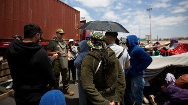 Inmigrantes de Venezuela son abordados por un carabinero cerca del paso fronterizo de Cachalluta con Perú, a unos 25 km al norte de Arica, Chile, el 28 de noviembre de 2025.