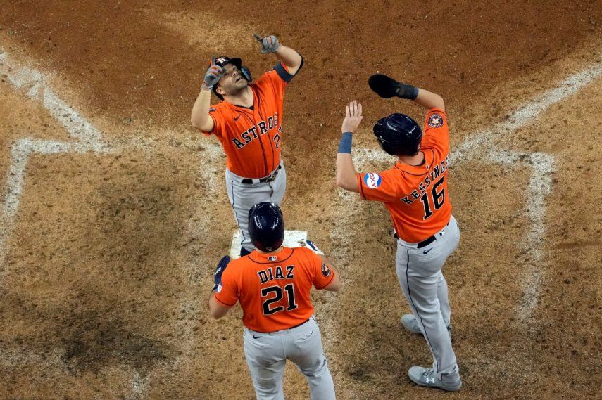 El venezolano José Altuve festeja con sus compañeros de los Astros de Houston, Yainer Díaz y Grae Kessinger, luego de remolcarlos con un jonrón en la novena entrada del quinto juego de la Serie de Campeonato de la Liga Americana ante los Rangers de Texas, el viernes 20 de octubre de 2023 