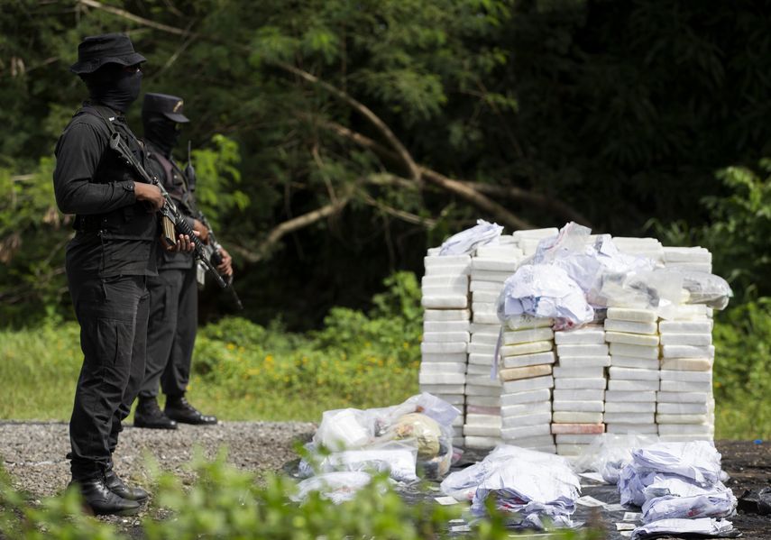Agentes dominicanos prestan guardia durante la incineración de 1297 kilos de diferentes drogas.