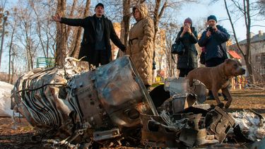 Gente de pie ante fragmentos de equipamiento militar en una calle tras un aparente ataque ruso en Járkiv, Ucrania, el jueves 24 de febrero de 2022. Tropas rusas lanzaron el jueves un amplio ataque sobre Ucrania, mientras el presidente, Vladimir Putin, restaba importancia a las sanciones y condenas internacionales y advertía a otros países que cualquier intento de intervenir tendría “consecuencias que nunca han visto”.