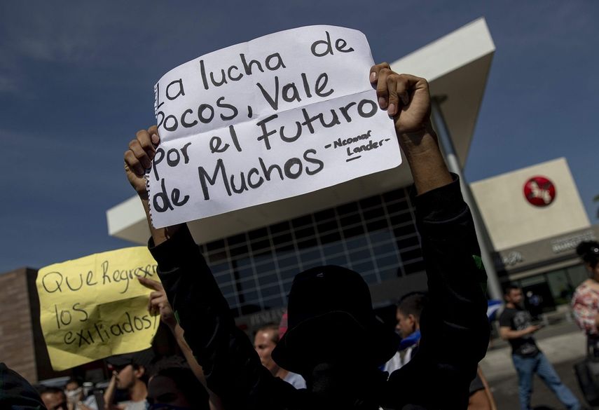 Un hombre sostiene un cartel durante una concentración para pedir la renuncia de Daniel Ortega en un centro comercial, en Managua, Nicaragua.&nbsp;