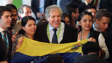 El secretario general de la OEA, Luis Almagro, junto a dos jóvenes venezolanas y una bandera de ese país.&nbsp;