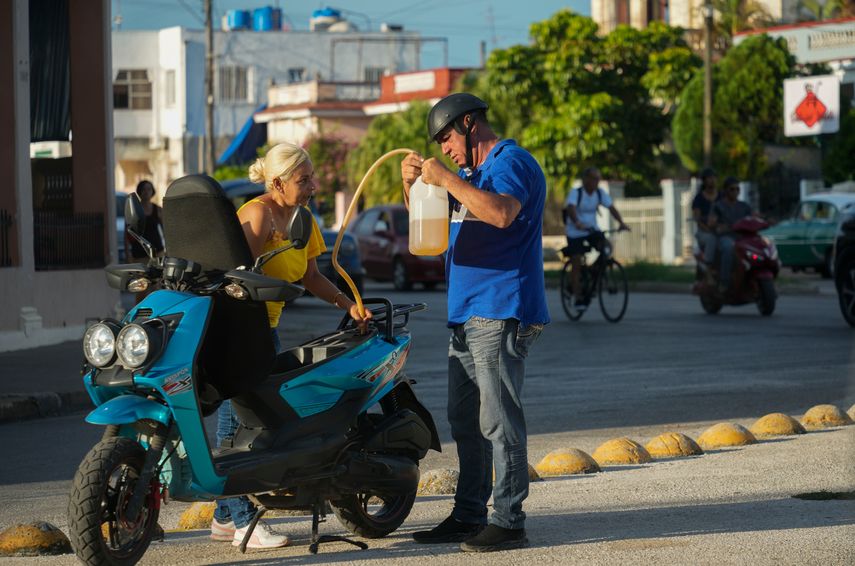 Un hombre llena su motocicleta con gasolina de un bidón de plástico en La Habana, Cuba. Un hombre llena su motocicleta con gasolina de un bidón de plástico en La Habana, Cuba.