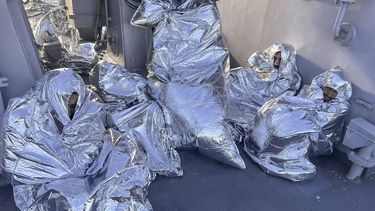 En esta foto distribuida por la Guardia Costera griega, algunos de los nueve sobrevivientes de un naufragio de migrantes, hallados en un islote deshabitado, se tapan con mantas térmicas en un buque guardacostas griego en el mar Egeo, Grecia, martes 1 de noviembre de 2022.&nbsp;