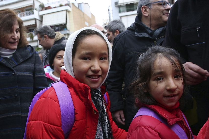 Dos niñas afganas son recibidas por padres, vecinos y profesores en su primer día de colegio en Atenas, Grecia. La Comisión Europea (CE) ha destinado a través de la Organización Internacional para las Migraciones (OIM) 2,8 millones de euros de ayuda para garantizar la asistencia escolar de los&nbsp;niñosrefugiados&nbsp;en Grecia. &nbsp;