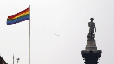 La bandera del arcoíris, símbolo de la comunidad LGBTQ, ondea sobre un edificio junto al monumento de Nelson en Trafalgar Square en el centro de Londres, Gran Bretaña, el viernes 28 de marzo de 2014.&nbsp;