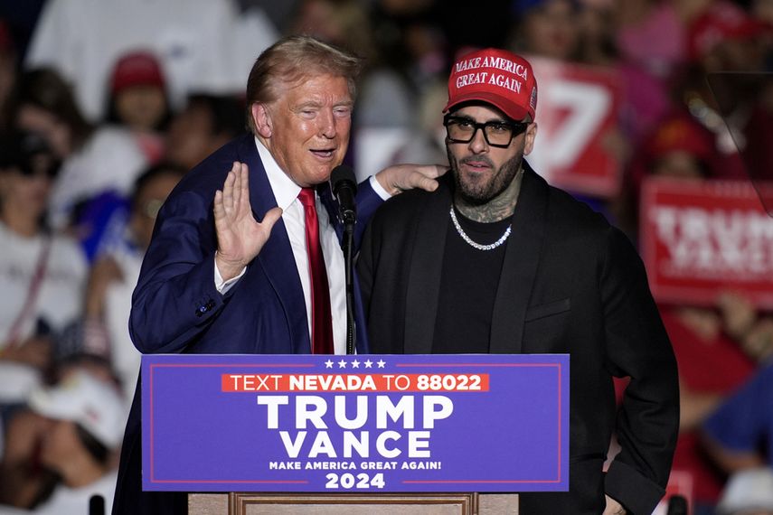 El expresidente Donald Trump, candidato presidencial republicano, a la izquierda, saluda a Nicky Jam durante un evento de campaña en el World Market Center, el viernes 13 de septiembre de 2024, en Las Vegas.