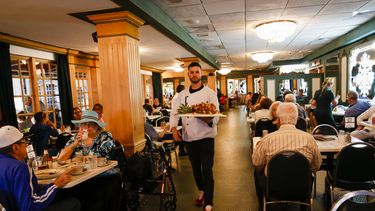 Un empleado sostiene una bandeja durante el 50 aniversario del restaurante Versailles en Miami, Florida, el 10 de noviembre de 2021.