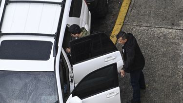 Un guardaespaldas escolta a un hombre cuando sale de su vehículo frente a un centro comercial en Caracas el 20 de abril de 2022. Tener guardaespaldas en Venezuela se ha convertido en un símbolo de estatus de una élite emergente. &nbsp;