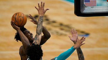 Jimmy Butler, centro, del Heat de Miami, intenta encestar frente a Miles Bridges, de los Hornets de Charlotte