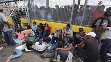 Migrantes de todas las nacionalidades se re&uacute;nen junto a una cerca fronteriza despu&eacute;s de acampar en el Puente Internacional Gateway que conecta el centro de Matamoros, M&eacute;xico, con Brownsville, Texas, el jueves 10 de octubre de 2019.&nbsp;
