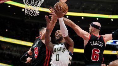 Damian Lillard de los Bucks de Milwaukee avanza hacia la canasta bajo presión de Nikola Vucevic y Alex Caruso de los Bulls de Chicago en el el encuentro del 30 de noviembre del 2023.&nbsp;