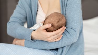 Una madre amamantando a su hijo.