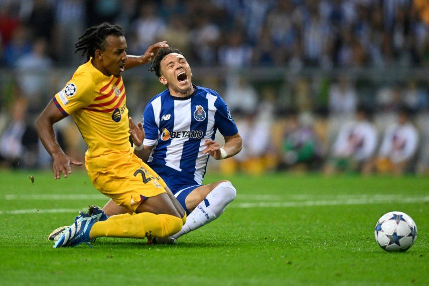 El defensa francés del Barcelona #23 Jules Kounde y el delantero brasileño del FC Porto #11 Pepe caen durante el partido de fútbol del grupo H de la primera ronda de la Liga de Campeones de la UEFA, día 2, entre el FC Porto y el FC Barcelona en el estadio Dragao de Oporto el 4 de octubre de 2023. &nbsp;