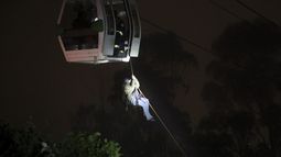 Esta imagen distribuida por el Cuerpo de Bomberos de Quito muestra a los bomberos rescatando pasajeros en las cabinas del teleférico de Quito, Ecuador, el 7 de julio de 2023.&nbsp;