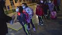 Un grupo de alumnos con mascarilla para prevenir contagios de coronavirus se desinfectan las manos mientras esperan en fila para entrar en la escuela Luis Amigo tras las vacaciones de Navidad, en Pamplona, en el norte de España, el lunes 10 de enero de 2021. 