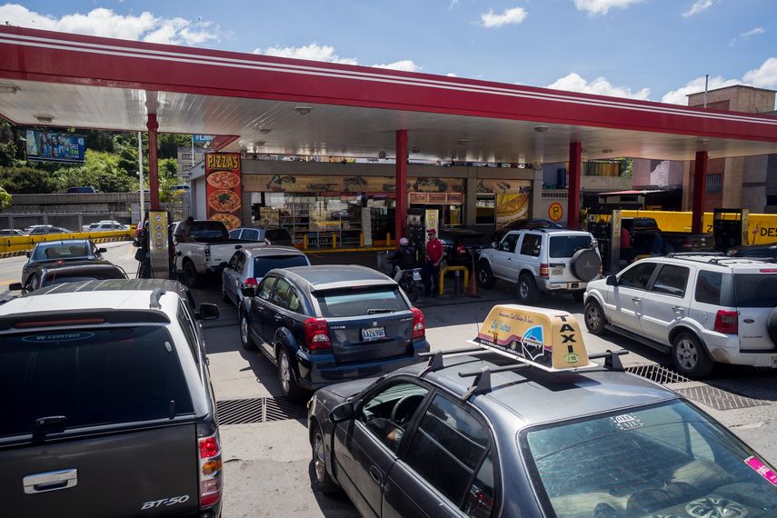 Conductores en Caracas hacen largas filas para abastecer sus vehículos de combustible debido a rumores sobre posible racionamiento del servicio.