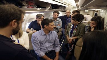 El presidente del Gobierno español Pedro Sánchez conversa con miembros de su delegación en el avión de la Fuerza Aérea española.