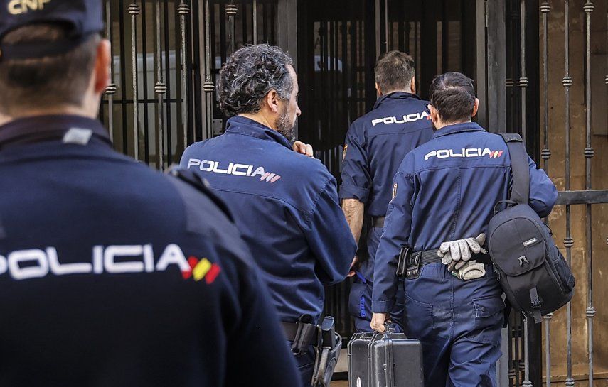 Varios agentes de la Policía Nacional ingresan a un edificio en la comunidad de Valencia, España.