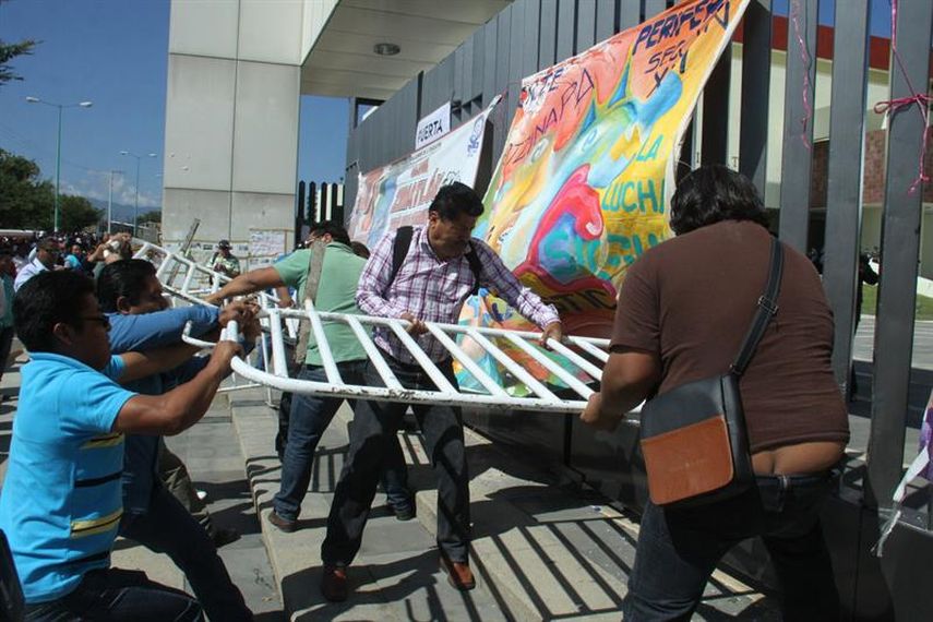 Imagen cedida por la agencia Quadratín, que muestra a un grupo de maestros de la sección 22 irrumpir en el Congreso del estado de Oaxaca para mostrar su apoyo a los estudiantes desaparecidos en Guerrero y exigir otras demandas. (Foto EFE)