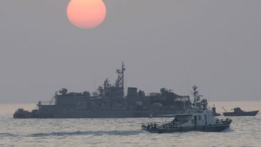 En esta imagen de archivo, tomada el 22 de diciembre de 2010, un barco del gobierno navega junto a una base naval flotante surcoreana al amanecer, cerca de la isla de Yeonpyeong, en Corea del Sur.&nbsp;