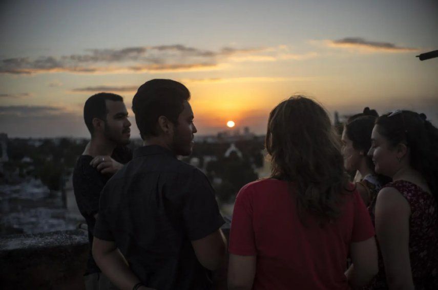 Marcos Marzo, segundo desde la izquierda, habla con sus amigos que vinieron a despedirse de él luego de recibir la noticia de que obtuvo un permiso para viajar a Estados Unidos, en La Habana, Cuba, el miércoles 25 de enero de 2023. 