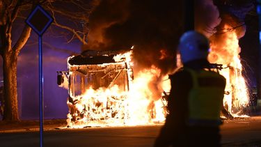 Policías antidisturbios observan el incendio de un autobús urbano en una calle de Malmo, Suecia, el sábado 16 de abril de 2022.&nbsp;