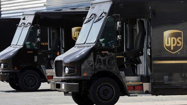 Camiones de la empresa de mensajería UPS estacionados en un centro de distribución en Boston.