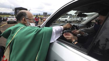El sacerdote cat&oacute;lico Luis Carlos Ayala, con una mascarilla para protegerse del coronavirus, entrega la comuni&oacute;n a los fieles el domingo 30 de agosto de 2020 durante una misa, en Chia, Colombia.&nbsp;