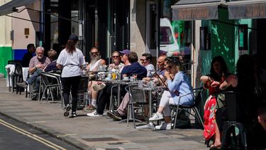 Personas disfrutan un día soleado en un restaurante en Soho, Londres,