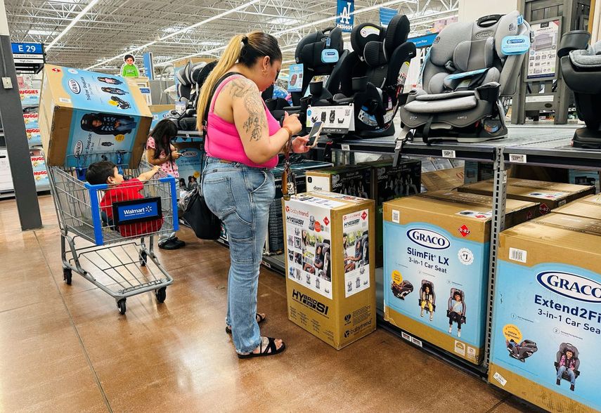 Una madre observa los precios de productos en un departamento para bebés.