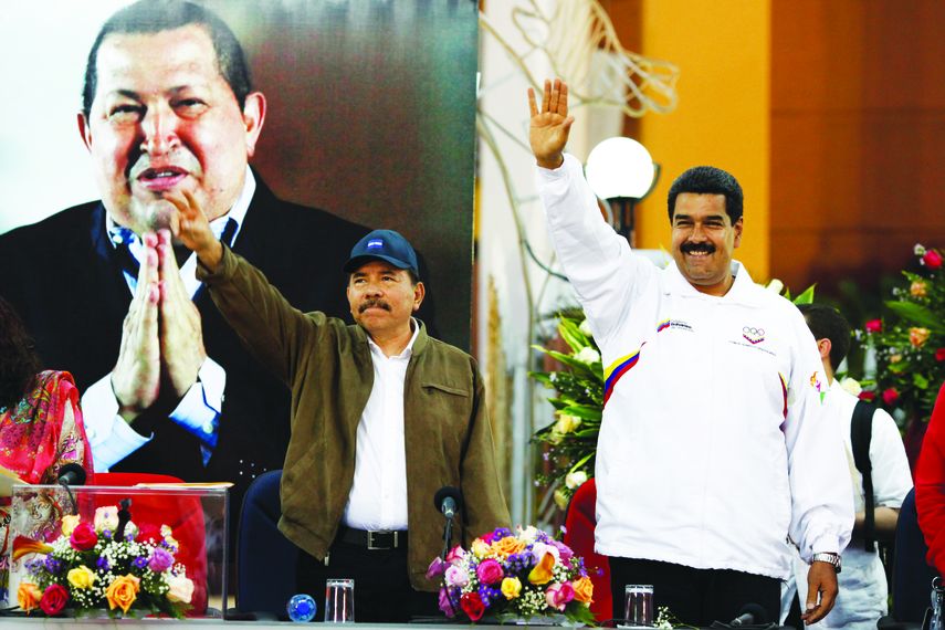Nicolás Maduro y Daniel Ortega, ante una foto de Hugo Chávez, saludan a simpatizantes