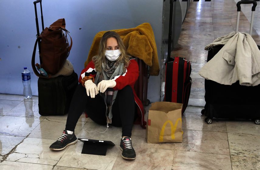 Una viajera lleva una mascarilla y guantes como precauci&oacute;n contra el nuevo coronavirus en el aeropuerto internacional Benito Ju&aacute;rez en Ciudad de M&eacute;xico el mi&eacute;rcoles 25 de marzo de 2020.