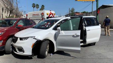 Un miembro de las fuerzas de seguridad de México está parado junto a una miniván blanca con placas de Carolina del Norte y varios hoyos de balas, en el lugar en donde hombres armados secuestraron a cuatro ciudadanos estadounidenses el 3 de marzo de 2023.