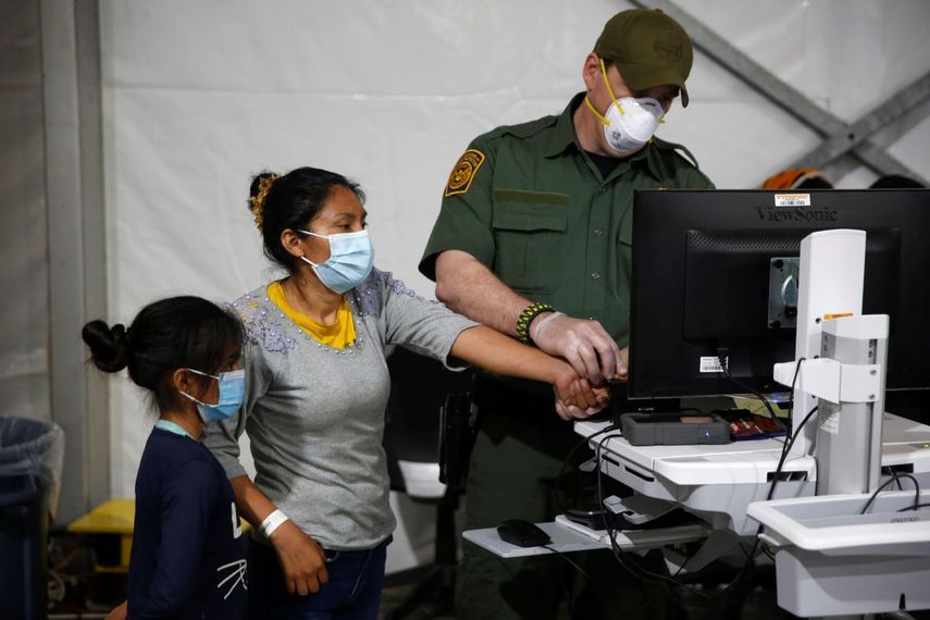 Esta fotografía de archivo del 30 de marzo de 2021 muestra cuando se toma la información biométrica a una migrante y su hija en un espacio asignado en el mayor centro de detención para niños no acompañados que tiene el Departamento de Seguridad Nacional en el Valle del Rio Grande, en Donna, Texas.